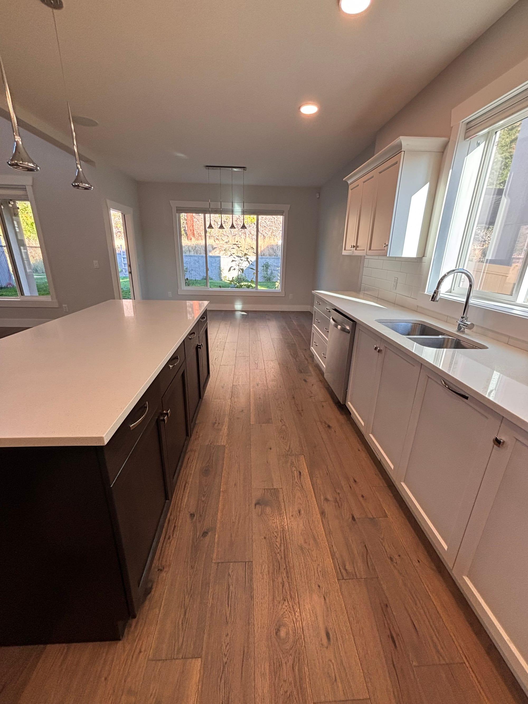 Empty kitchen after a move out clean, with clear counters, wiped cupboards and washed floors